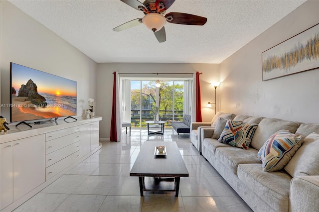 living room featuring ceiling fan and a textured ceiling