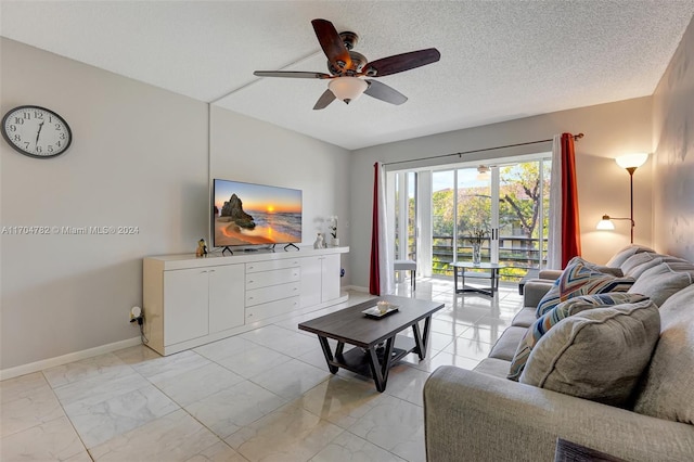 living room with ceiling fan and a textured ceiling