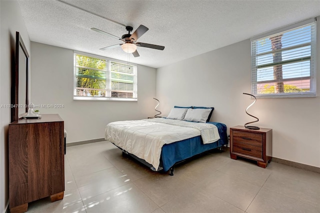 bedroom with a textured ceiling, multiple windows, and ceiling fan