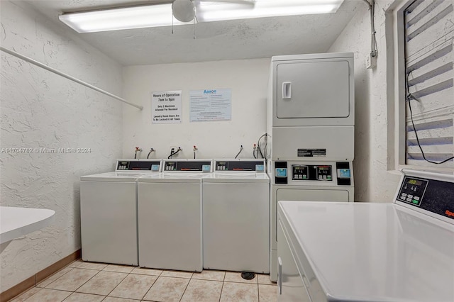 clothes washing area featuring stacked washer and clothes dryer, ceiling fan, independent washer and dryer, light tile patterned floors, and a textured ceiling