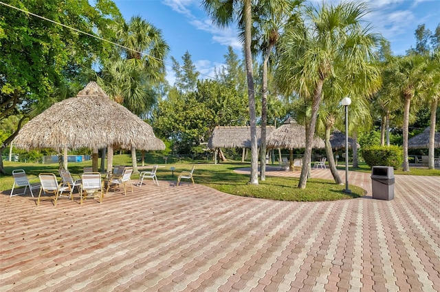 view of community featuring a gazebo, a wooden deck, and a lawn