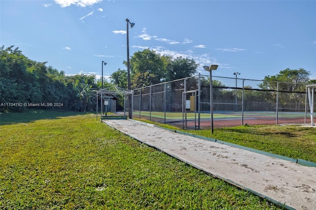 view of sport court with a lawn