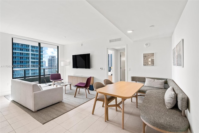 living room with light tile patterned floors and a wall of windows