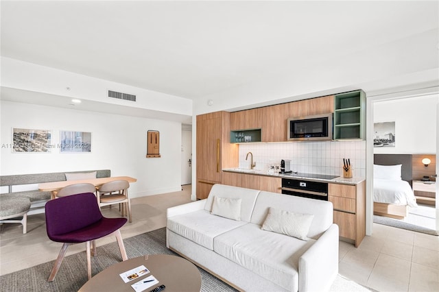 living room featuring sink and light tile patterned floors