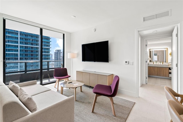 living room featuring expansive windows and light tile patterned floors