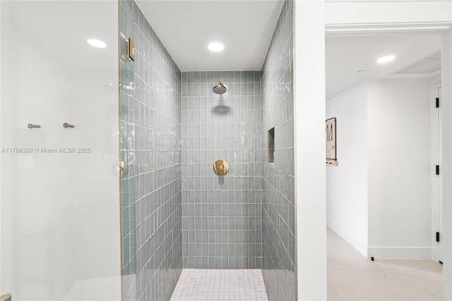 bathroom with a tile shower and tile patterned floors