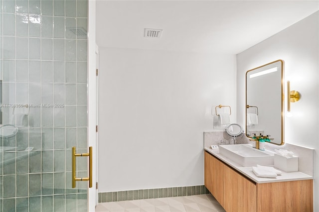 bathroom featuring tile patterned flooring, a shower, and vanity