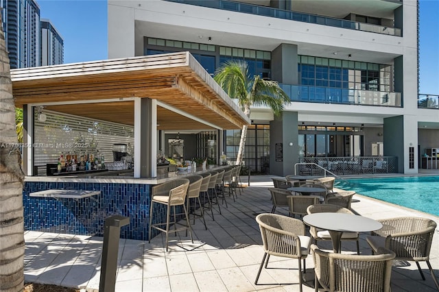 view of pool with a bar and a patio