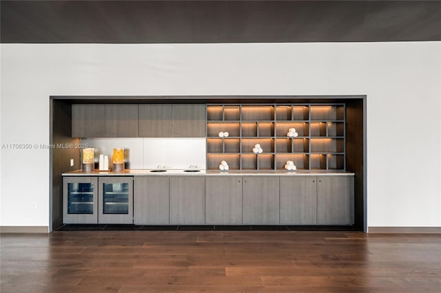 bar featuring wine cooler, gray cabinetry, and dark hardwood / wood-style floors