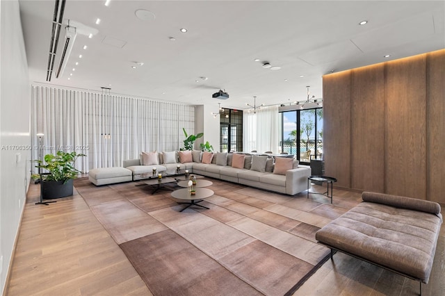 living room featuring a chandelier, expansive windows, and light hardwood / wood-style flooring