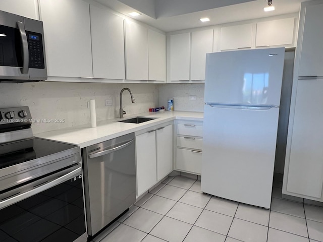 kitchen with white cabinetry, stainless steel appliances, sink, and light tile patterned floors