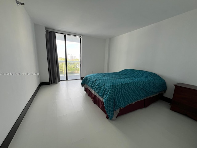 bedroom with floor to ceiling windows and access to exterior