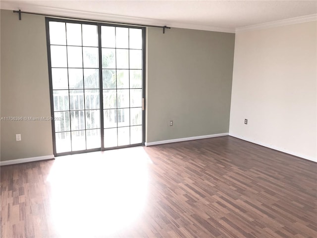 unfurnished room with dark hardwood / wood-style flooring and crown molding