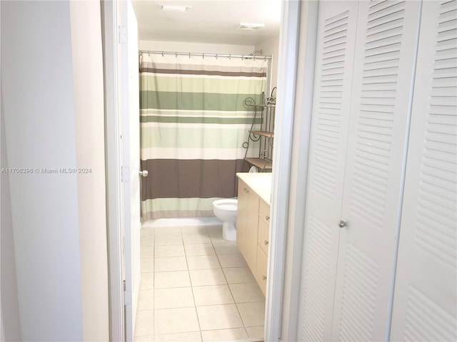 bathroom with toilet, vanity, and tile patterned floors