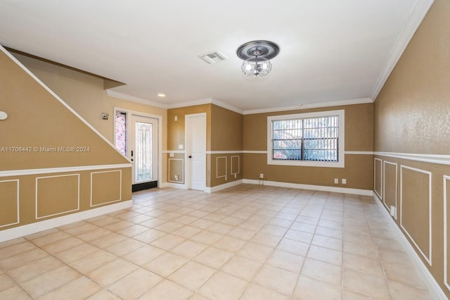 empty room with ornamental molding and light tile patterned flooring