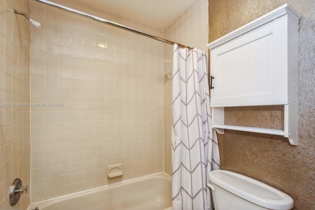 bathroom featuring shower / tub combo and toilet