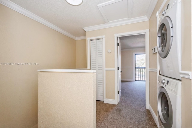 clothes washing area with a textured ceiling, light colored carpet, stacked washer / dryer, and crown molding