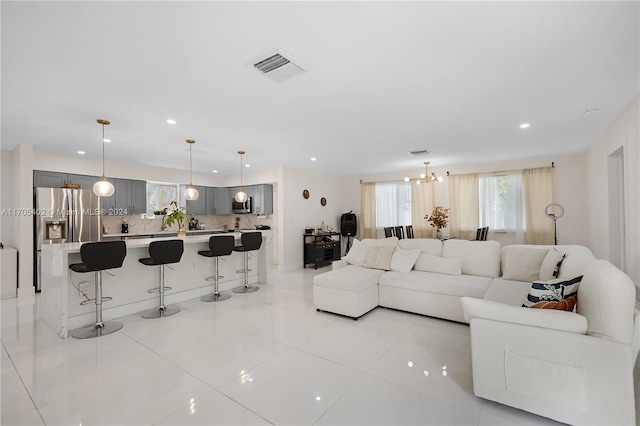 living room with a notable chandelier and light tile patterned floors