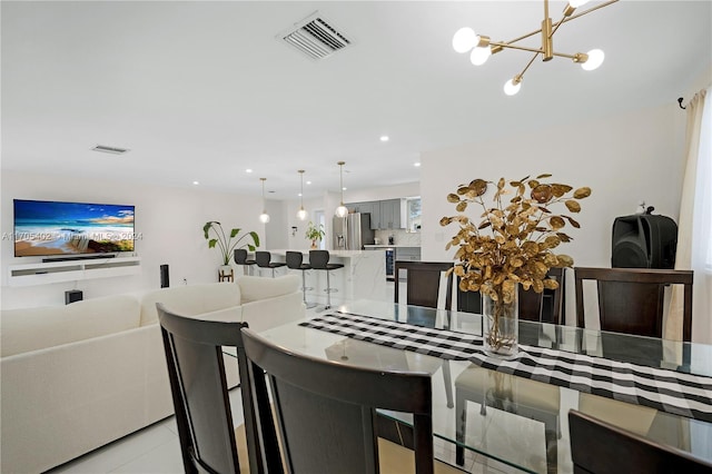 tiled dining room with an inviting chandelier