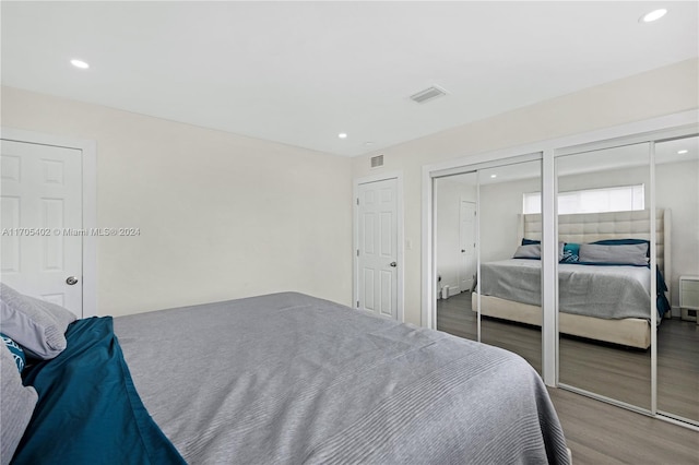 bedroom with hardwood / wood-style floors and two closets