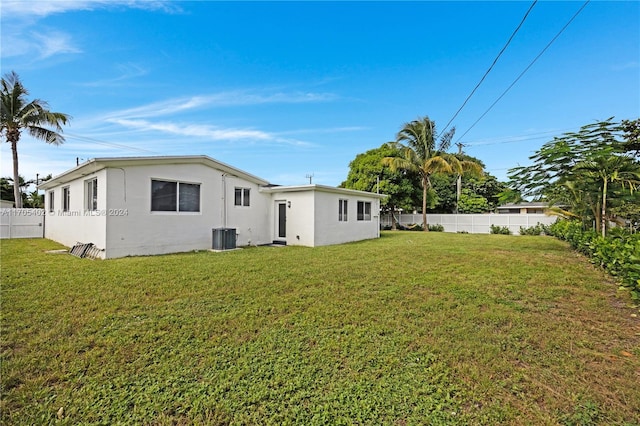 rear view of house featuring a yard and central AC