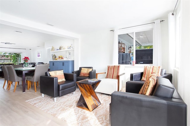 living room with ceiling fan, light hardwood / wood-style flooring, and a healthy amount of sunlight