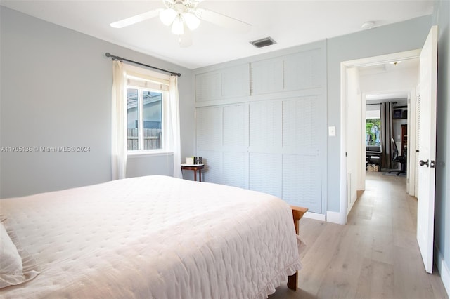 bedroom with ceiling fan, a closet, and light hardwood / wood-style floors