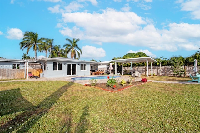 back of property with a yard, a fenced in pool, and a patio area