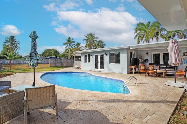 view of pool featuring outdoor lounge area, french doors, and a patio