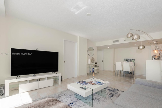 living room with light tile patterned flooring and a textured ceiling