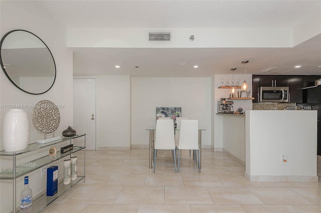 tiled dining area with a textured ceiling