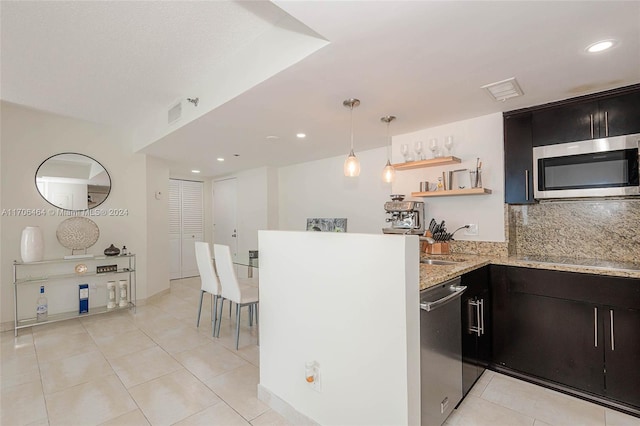 kitchen featuring decorative backsplash, appliances with stainless steel finishes, light tile patterned floors, and light stone counters