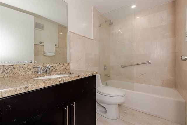 full bathroom with toilet, tile patterned flooring, vanity, and tiled shower / bath