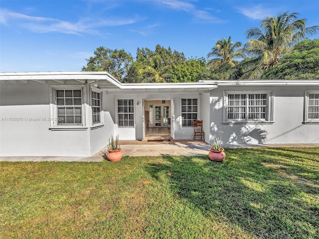 rear view of house featuring a patio area and a yard