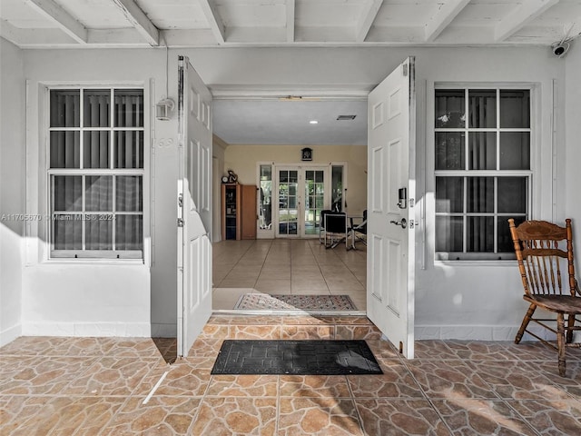 view of exterior entry with a patio and french doors