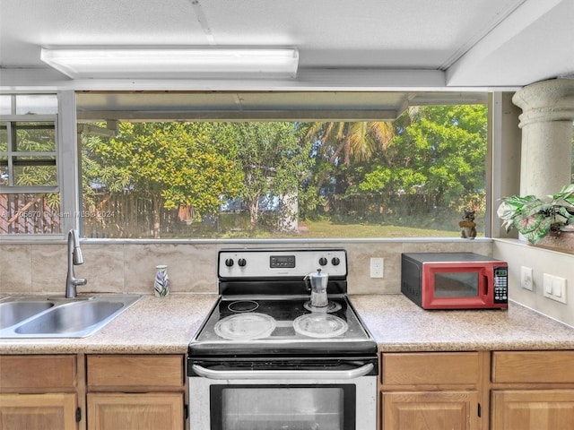 kitchen with decorative backsplash, light brown cabinetry, stainless steel electric range oven, and sink