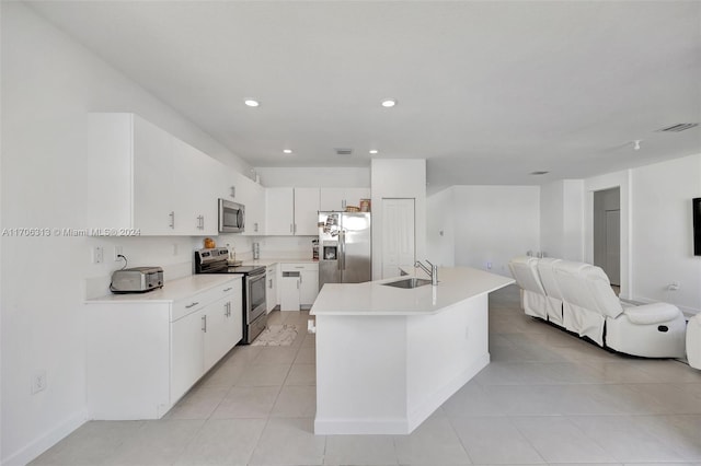 kitchen featuring a center island, white cabinets, sink, appliances with stainless steel finishes, and light tile patterned flooring