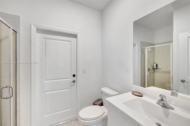 bathroom with toilet, an enclosed shower, and vanity