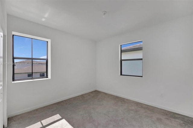 unfurnished room featuring light colored carpet