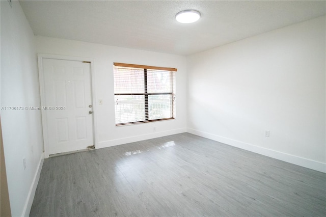 unfurnished room with a textured ceiling and hardwood / wood-style flooring