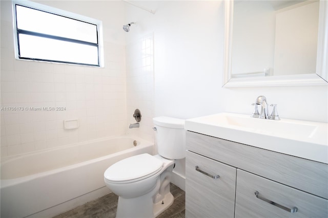 full bathroom with hardwood / wood-style floors, vanity, toilet, and tiled shower / bath combo