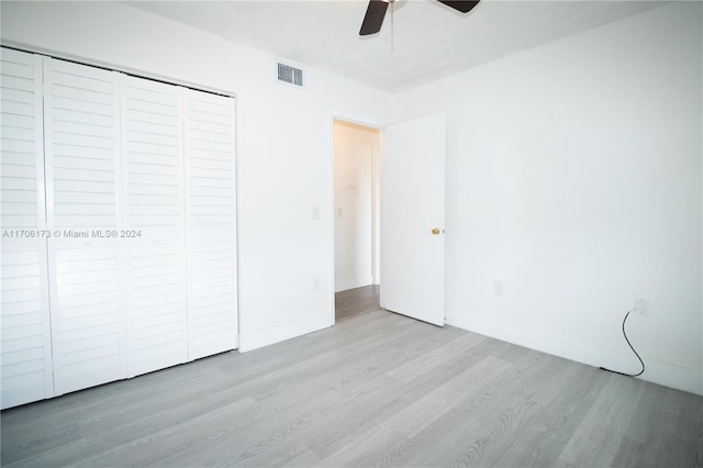 unfurnished bedroom with light wood-type flooring, a closet, and ceiling fan