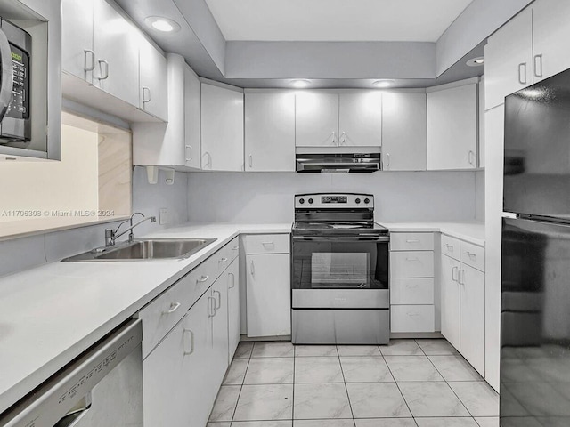 kitchen with white cabinets, stainless steel appliances, light tile patterned flooring, and sink