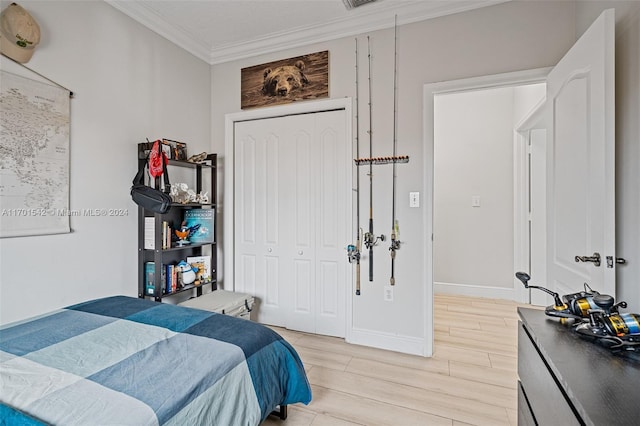 bedroom with light wood-type flooring, a closet, and crown molding