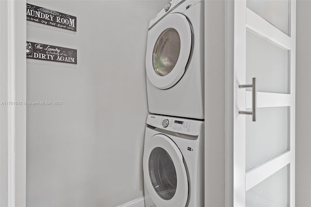 clothes washing area with stacked washer / dryer