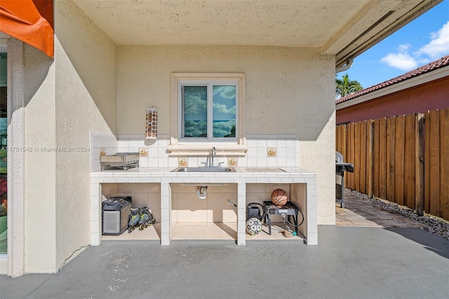 view of patio featuring area for grilling, sink, and an outdoor fireplace