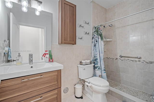 bathroom with vanity, tile patterned floors, toilet, tile walls, and curtained shower