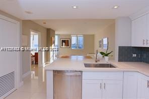 kitchen featuring dishwasher, sink, light tile patterned flooring, decorative backsplash, and white cabinets