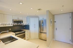 kitchen with white cabinetry, sink, and appliances with stainless steel finishes