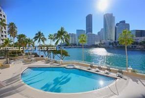 view of swimming pool featuring a water view and a patio area